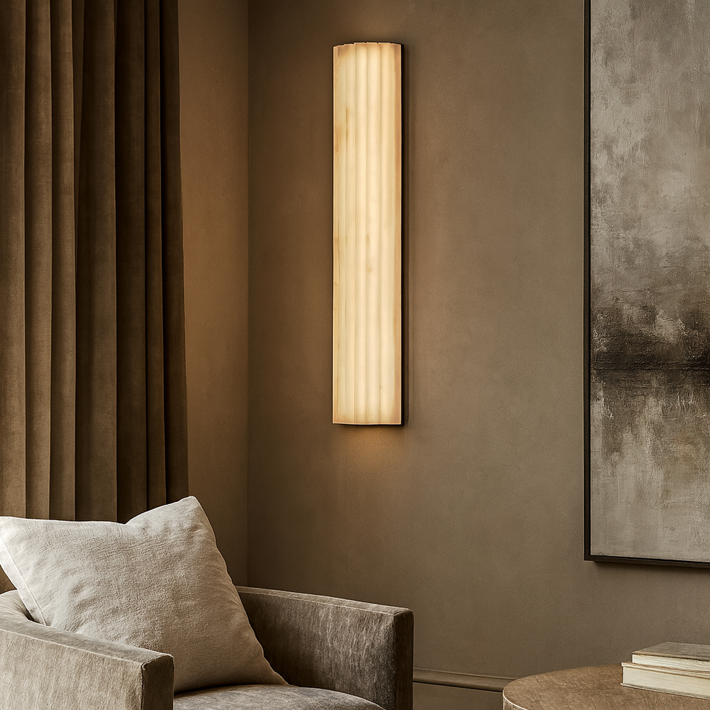 
                  
                    A modern living room with beige walls, a soft armchair with a cushion, floor-length curtains, and the Marlo Marble Wall Sconce 18" by Morsale alongside an abstract painting for a contemporary touch.
                  
                