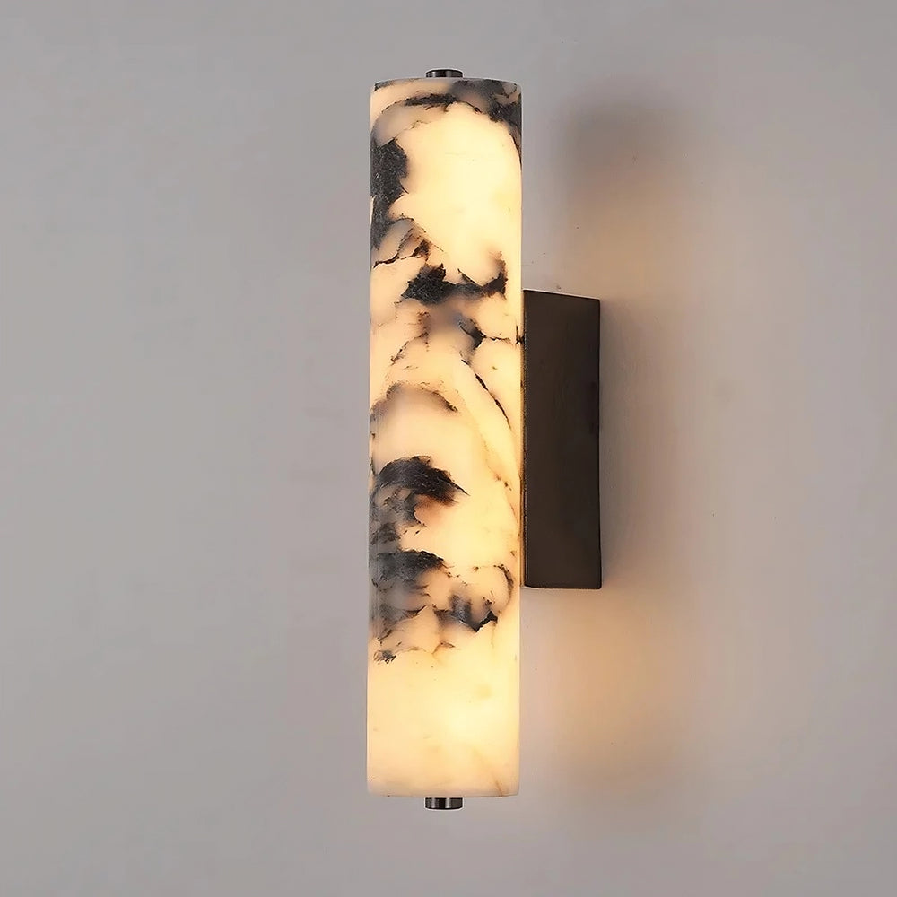 
                  
                    The Valmont Marble Cylinder Sconce by Morsale features a white and black marbled cylindrical design, emits a warm glow, and is mounted on a rectangular dark base for a modern touch.
                  
                