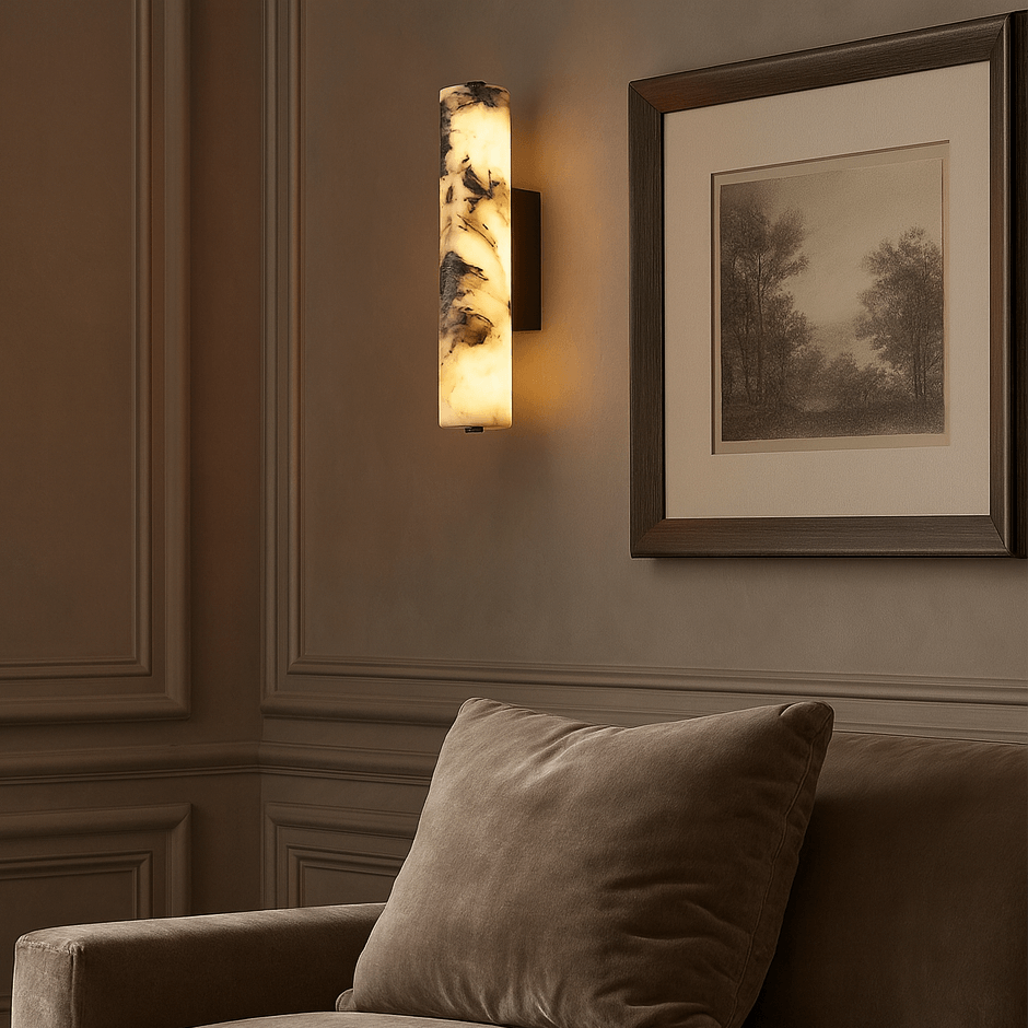Wall sconce and framed artwork in a room with a sofa and pillow.