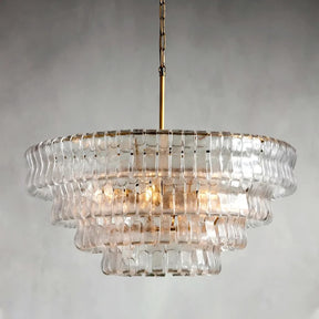 The Morsale Riviera Vintage French Crystal Chandelier, with its brass rod and chain, hangs elegantly from the ceiling. Its clear, rippled glass pieces are tiered beautifully, offering a classic touch against a plain gray background.