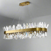 A modern, rectangular ceiling chandelier with a sleek, gold metal frame hangs elegantly from the ceiling. Featuring multiple elongated K9 crystal-like pendants arranged in a jagged pattern, this Calvi Crystal Dining Room Chandelier by Morsale.com reflects light beautifully to create a stylish and sophisticated ambiance.