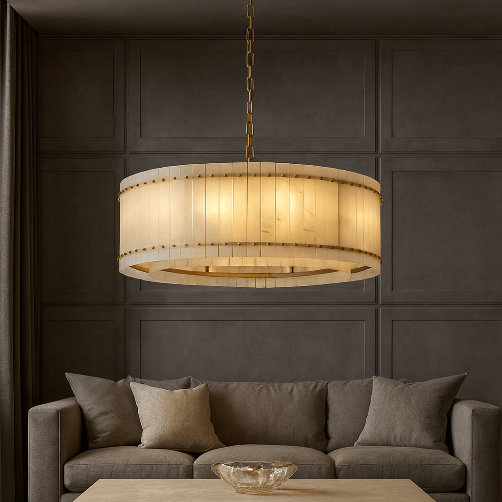 A modern living room showcases the Morsale Valmont Marble Round Chandelier 39" above a beige sofa with neutral cushions and a light wood coffee table with a glass bowl, set against a dark paneled wall.