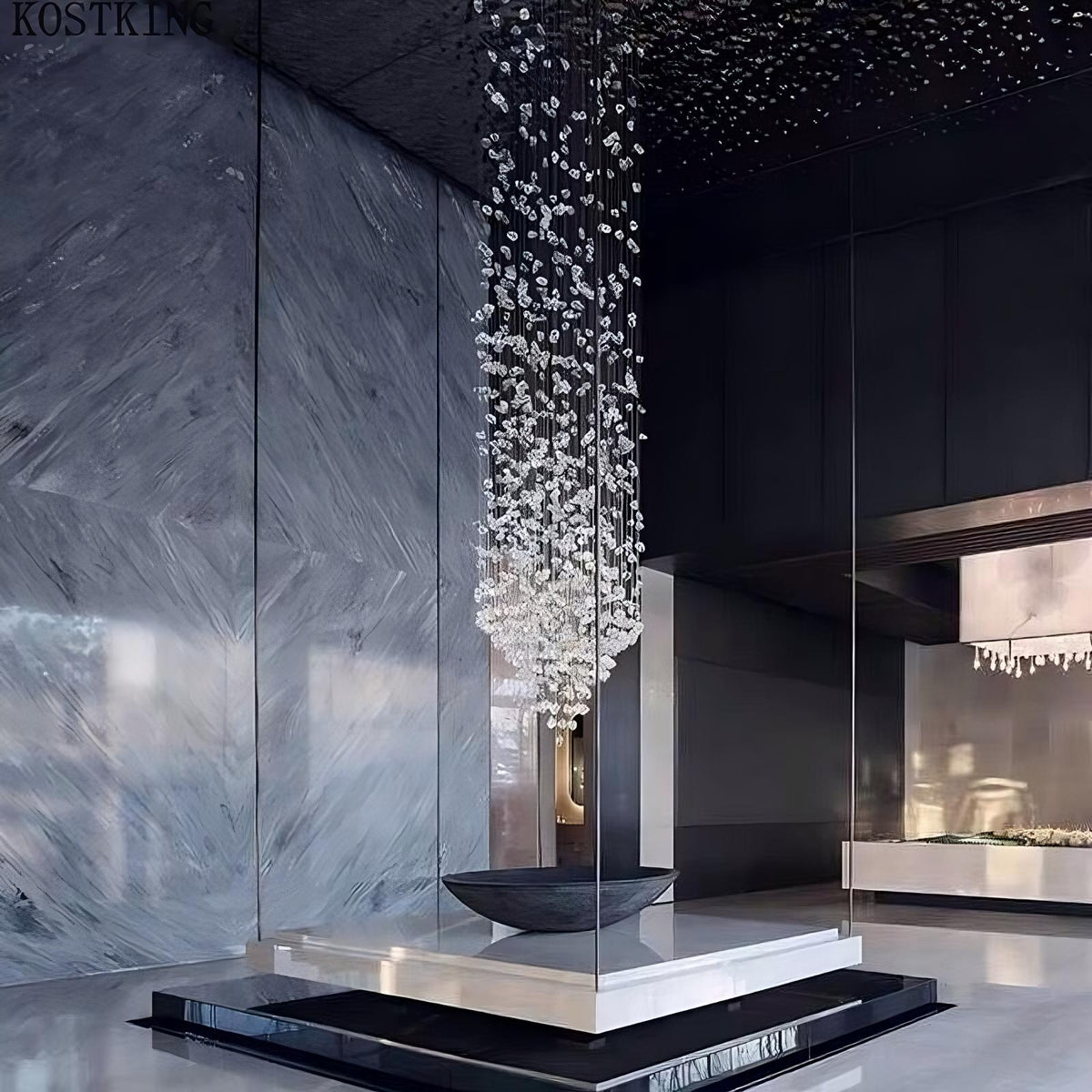 A modern, minimalist lobby showcasing the Multi Crystal Pendant Duplex Chandelier by Morsale.com, featuring cascading crystal light fixtures suspended above a sleek black pedestal with a contemporary reception desk in the background. The walls have a glossy, marble-like finish, and the ceiling is dark with spotlights.