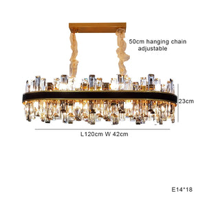 The Calvi Modern Dining Room Chandelier by Morsale.com features a rectangular crystal design with high-quality materials. Measuring 120 cm in length, 42 cm in width, and 23 cm in height, it has an adjustable 50 cm hanging chain and uses 18 E14 bulbs. Multiple hanging crystals adorn the gold-colored base for a stunning modern aesthetic.