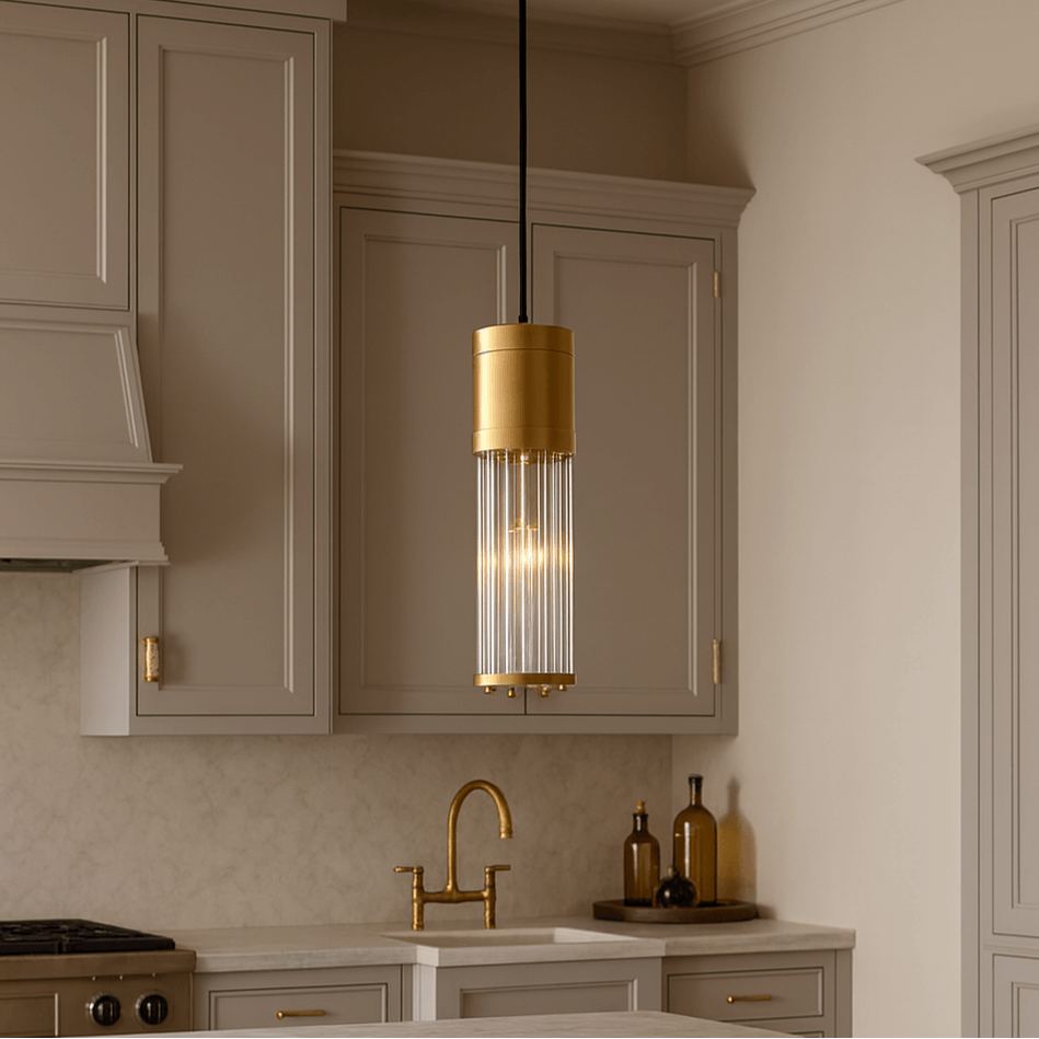 A modern kitchen with light beige cabinets, a gold faucet, and the striking Xihkonga Barnes Kitchen Island Pendant Light above the counter. A stove, backsplash, and decorative bottles complete the elegant look with standout kitchen island lighting.