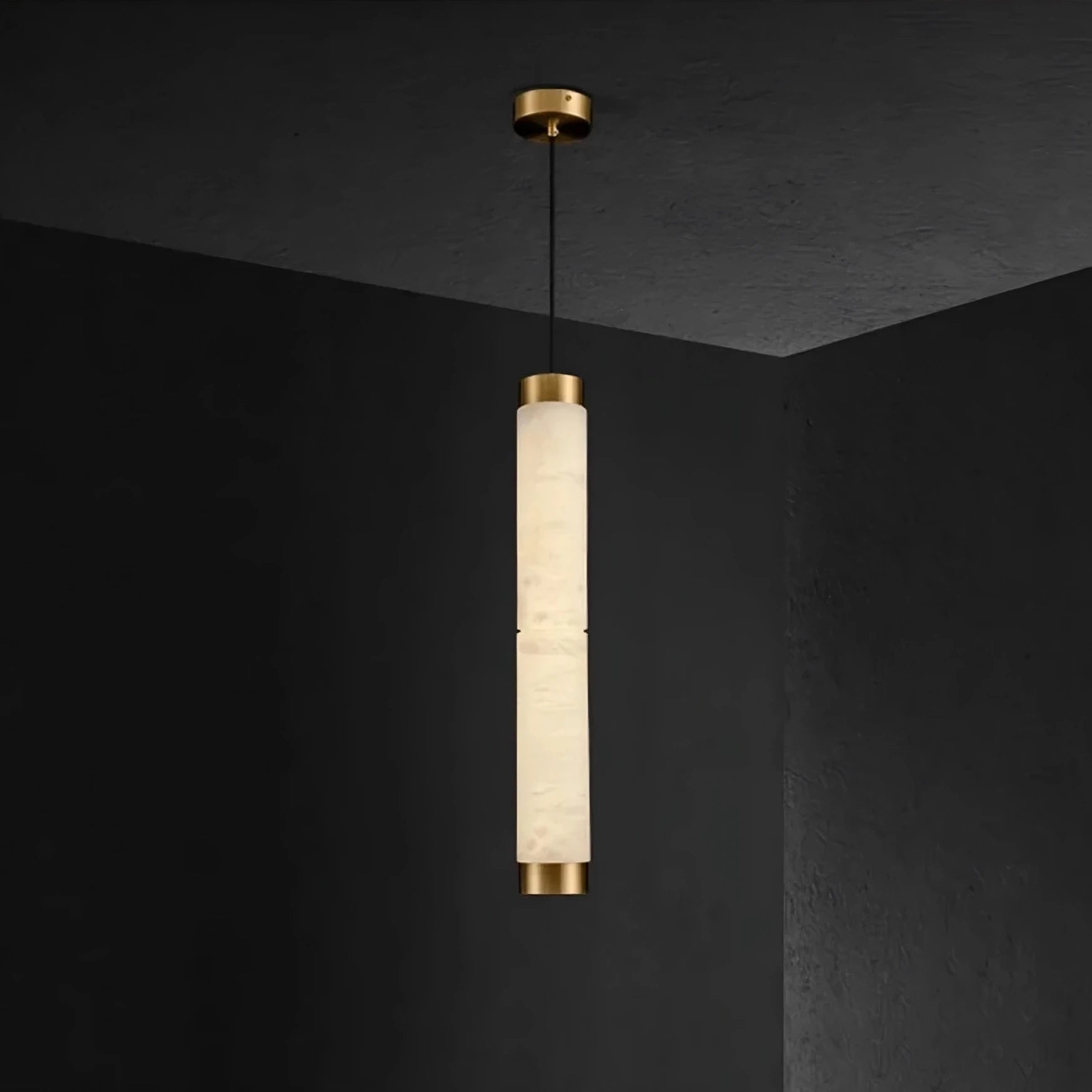 A sleek, cylindrical 23" Natural Marble Pendant Light from Morsale.com hangs from the ceiling. This light fixture features a matte, fabric-textured center and emits a warm, soft glow. It is suspended against a dark wall, creating a striking contrast that enhances modern home décor.