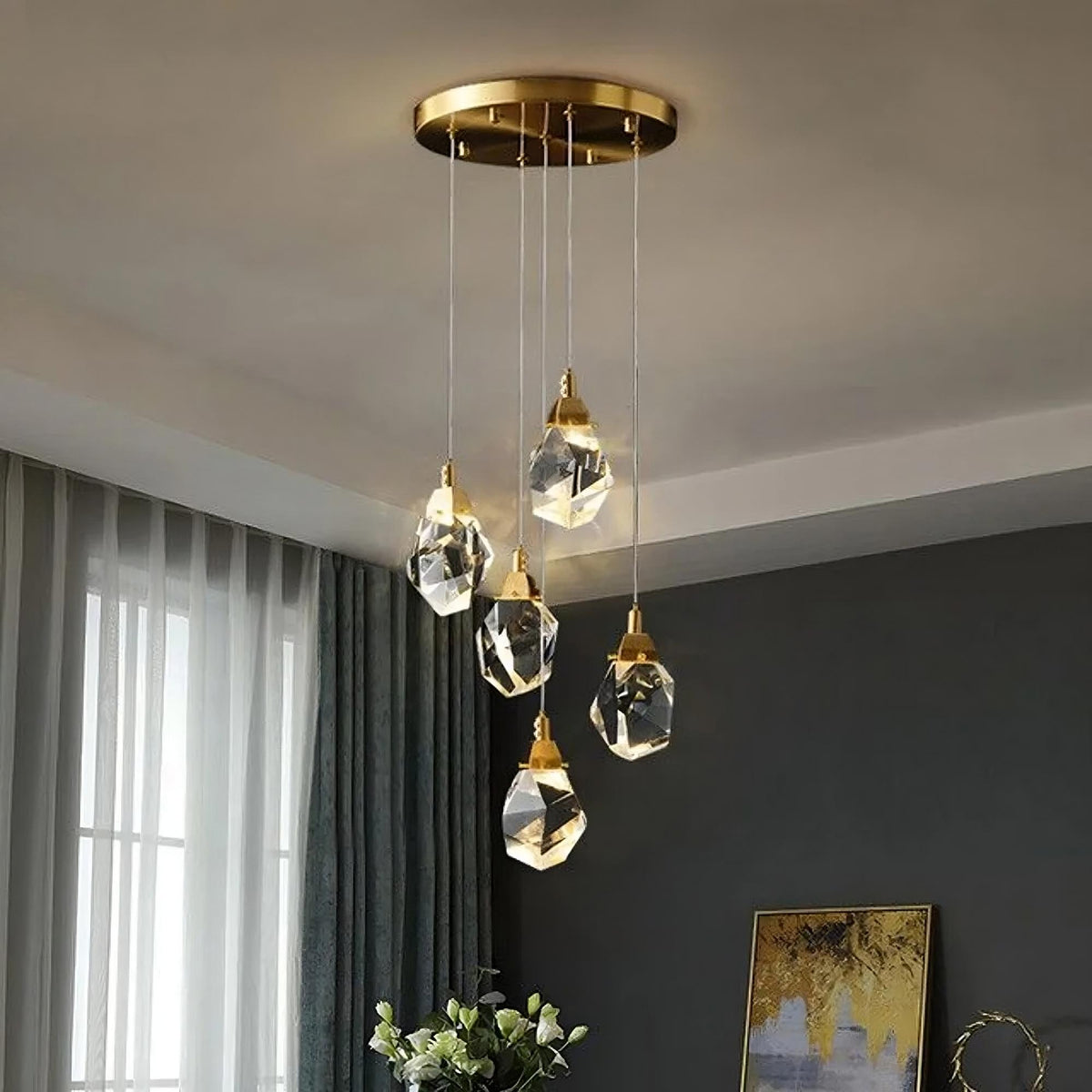 Introducing the Diamante 5-Light Crystal Pendant Light Fixture from Morsale.com, a modern chandelier featuring geometric clear crystal pendants gracefully hanging from a circular brass ceiling mount. This exquisite piece consists of five angular crystal elements suspended at varying lengths by thin wires, creating a stunning pendant light effect against a dark background.