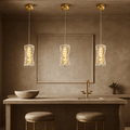 Bacci Crystal Pendant Light illuminating a modern kitchen with elegant gold accents and minimalist decor.