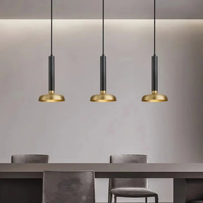 A stylish dining area featuring three Morsale All Copper Modern Pendant Lights with LED bulbs hanging above a sleek gray table and chairs, set against a light gray wall. The minimalist design underscores simplicity and elegance.