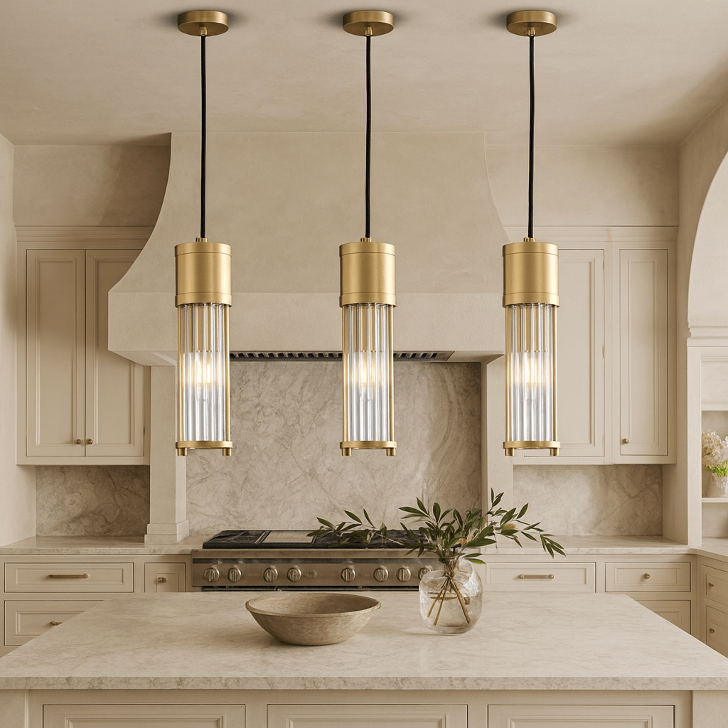 A modern kitchen with beige cabinets and marble surfaces showcases three Xihkonga Barnes Kitchen Island Pendant Lights above the island. A bowl and a vase with greenery add charm, making the lighting both functional and elegant.