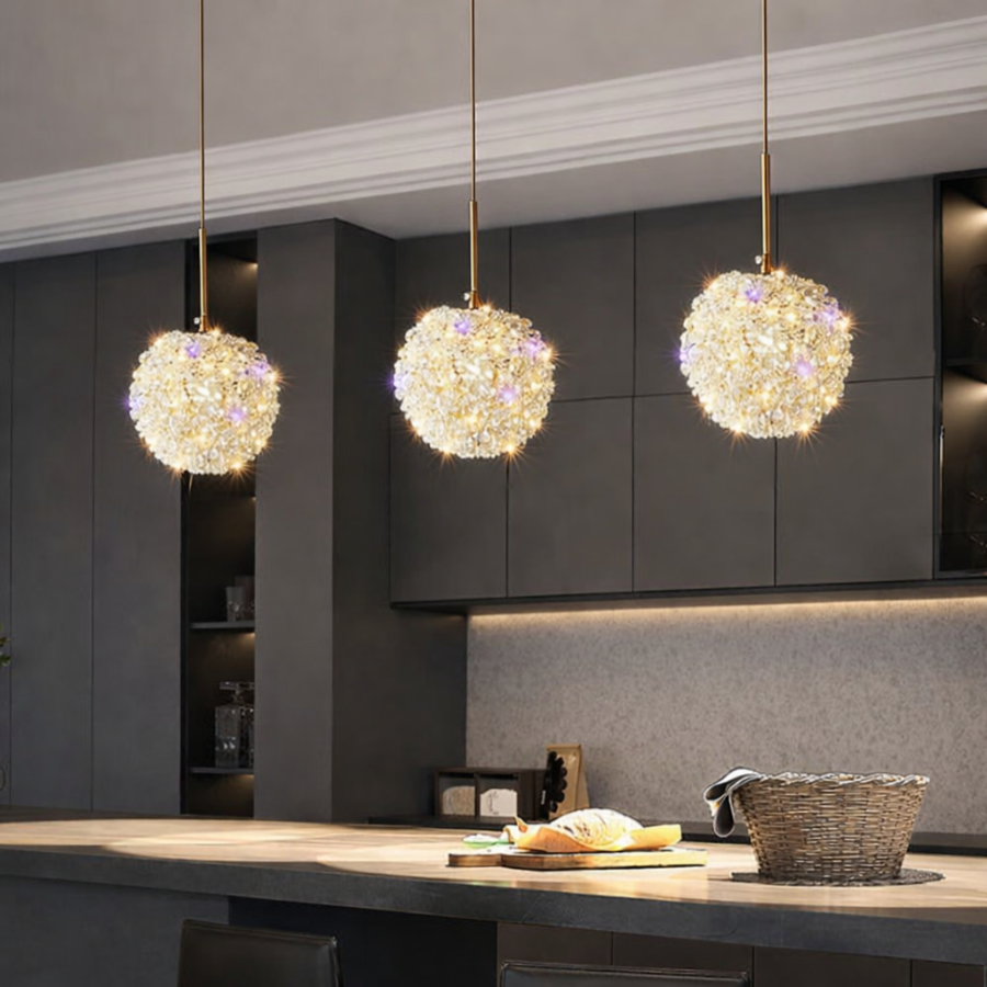 Three Amri Crystal Pendants by Morsale.com hang above a modern kitchen island with sleek dark cabinets, a woven basket, and a loaf of bread, adding elegant modern lighting to the space.