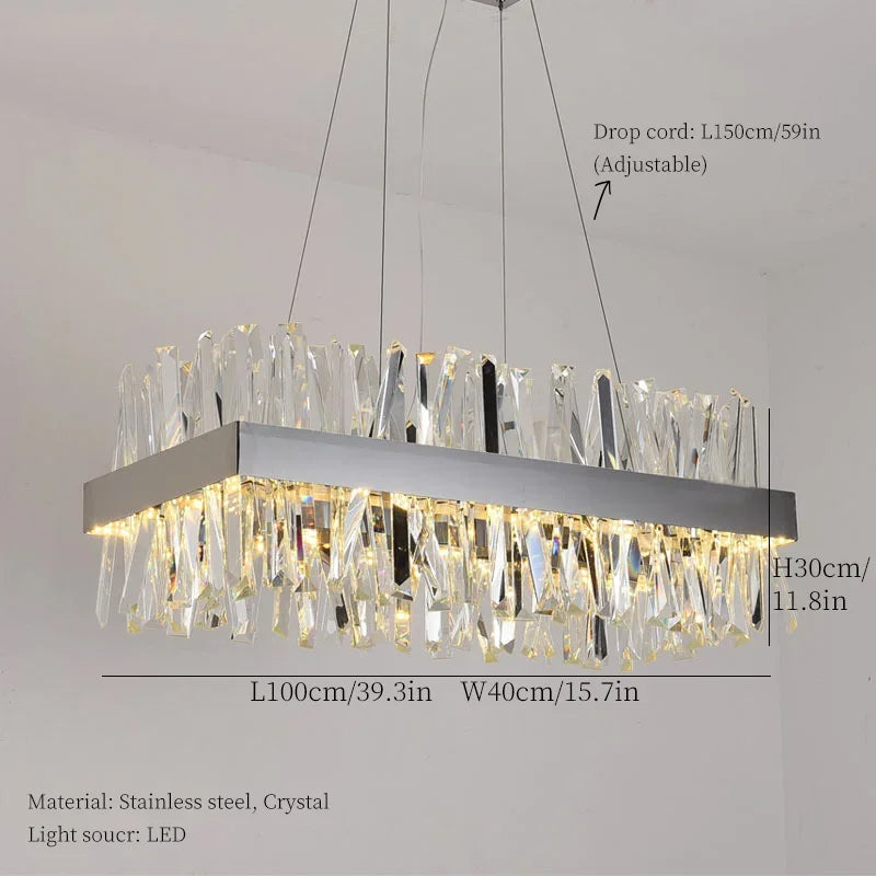 The Calvi Crystal Dining Room Light Fixture from Morsale.com features a modern rectangular chandelier with a stainless steel frame and multiple K9 crystal prisms, hanging elegantly from three adjustable drop cords. The dimensions are: drop cord length is 150 cm/59 in, fixture length is 100 cm/39.3 in, width is 40 cm/15.7 in, and height is 30 cm/11.8 in. The light source utilizes LED technology.