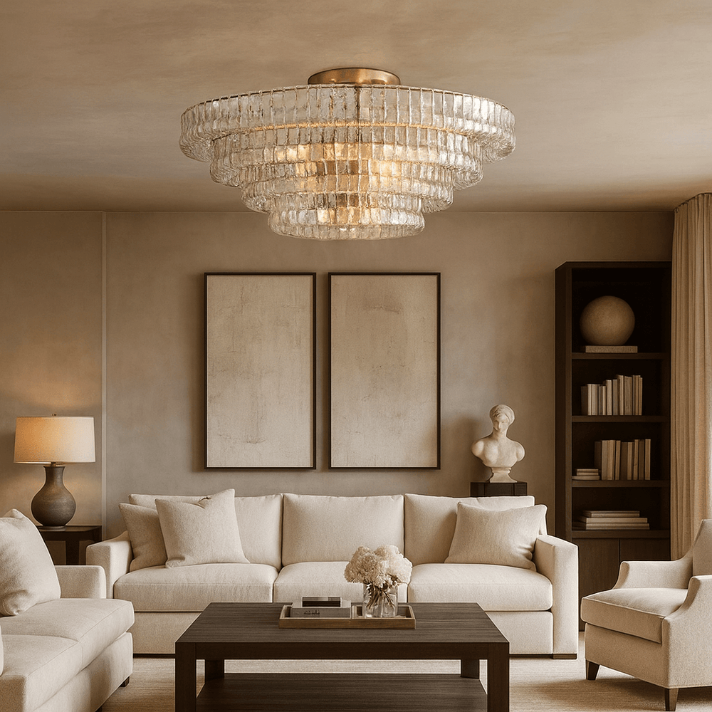 A modern living room with cream sofas, dark coffee table, decorative bust, bookshelves, and two abstract art pieces features the Morsale Riviera 35" Flush Mount chandelier with hand-cast glass shades and neutral-toned walls.