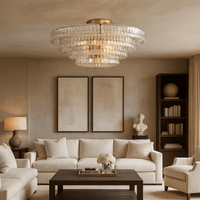 A modern living room with cream sofas, dark coffee table, decorative bust, bookshelves, and two abstract art pieces features the Morsale Riviera 35" Flush Mount chandelier with hand-cast glass shades and neutral-toned walls.