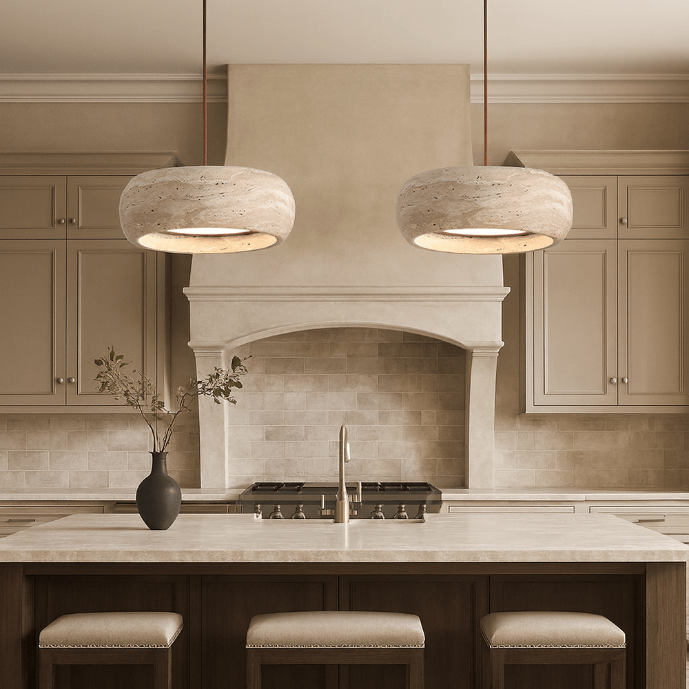 
                  
                    A modern kitchen with beige cabinets, a large stove, marble countertops, and a dark vase on the island features minimalist lighting with two Vero Travertine Bell Pendants by Morsale, enhancing its neutral-toned design.
                  
                