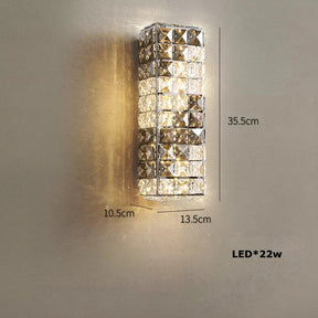 A Morsale Bacci Smoke & Clear Crystal Wall Sconce with a geometric design, made from natural marble and emitting warm light, is mounted on a beige wall. The sustainable lighting sconce measures 35.5cm in height, 13.5cm in width, and 10.5cm in depth, featuring an integrated LED with a brightness specification of LED*22W.