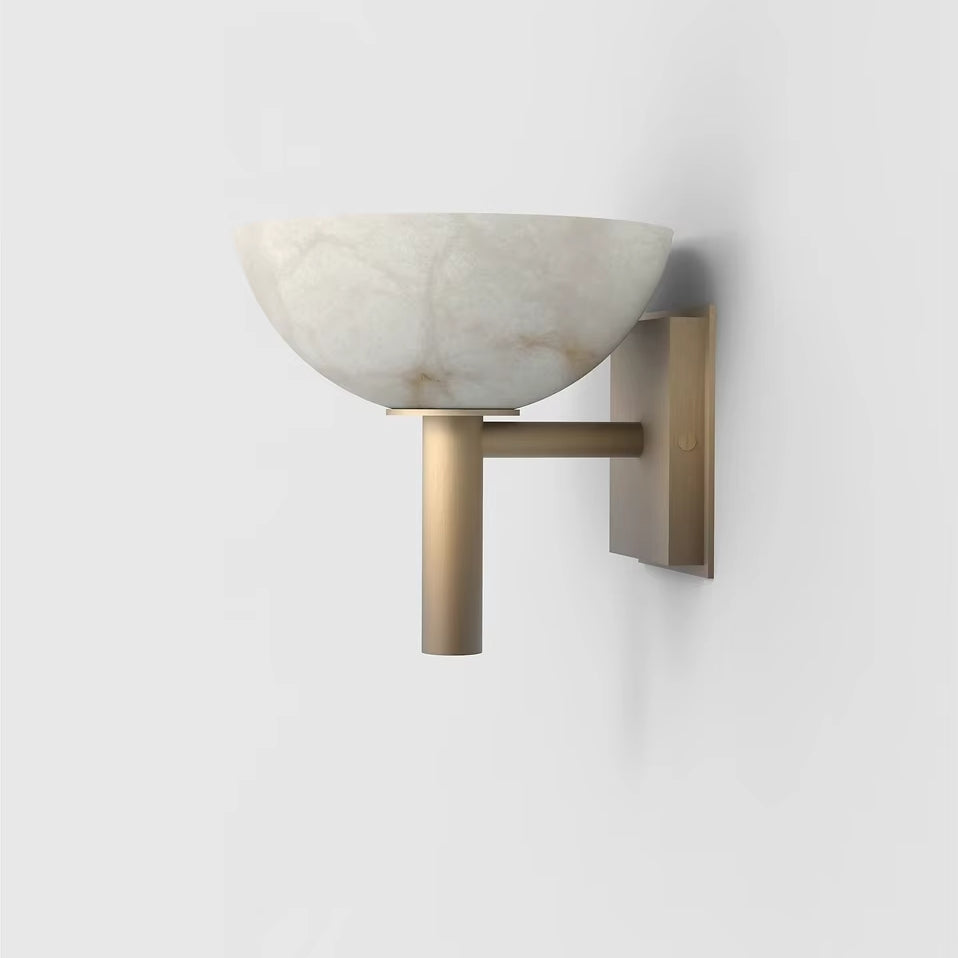 The Spanish Marble & Copper Antique Sconce by Morsale is a modern wall fixture featuring a semi-circular white Spanish marble shade and a brass mount. Its minimalist and elegant design creates a soft ambient glow.