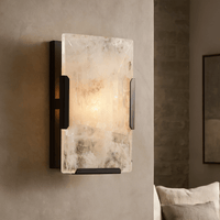 The Brookhill Calcite Crystal Wall Sconce by Morsale.com features a rectangular translucent stone shade and dark iron frame, casting a soft glow on neutral walls and enhancing minimalist decor.
