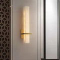Aresso Marble Wall Sconce illuminating a modern space with warm light and stylish gold accents.