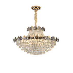 The Morsale Gioro Contemporary Chandelier showcases a polished golden base and multiple tiers of clear crystal droplets. It features intricate floral designs around the middle, enhancing its elegant and opulent appearance. This luxurious chandelier is suspended by a decorative golden chain.