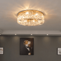 The Specchio Flush Mount Crystal Ceiling Light from Morsale.com, featuring warm LED illumination, is mounted on a white ceiling above a dark wall with a dog-in-suit painting and two framed quotes.