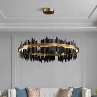 The Rivaro Modern Chandelier by Morsale.com, featuring a gold circular frame and jagged black accents, hangs above a sofa with patterned cushions in this neutral living room.
